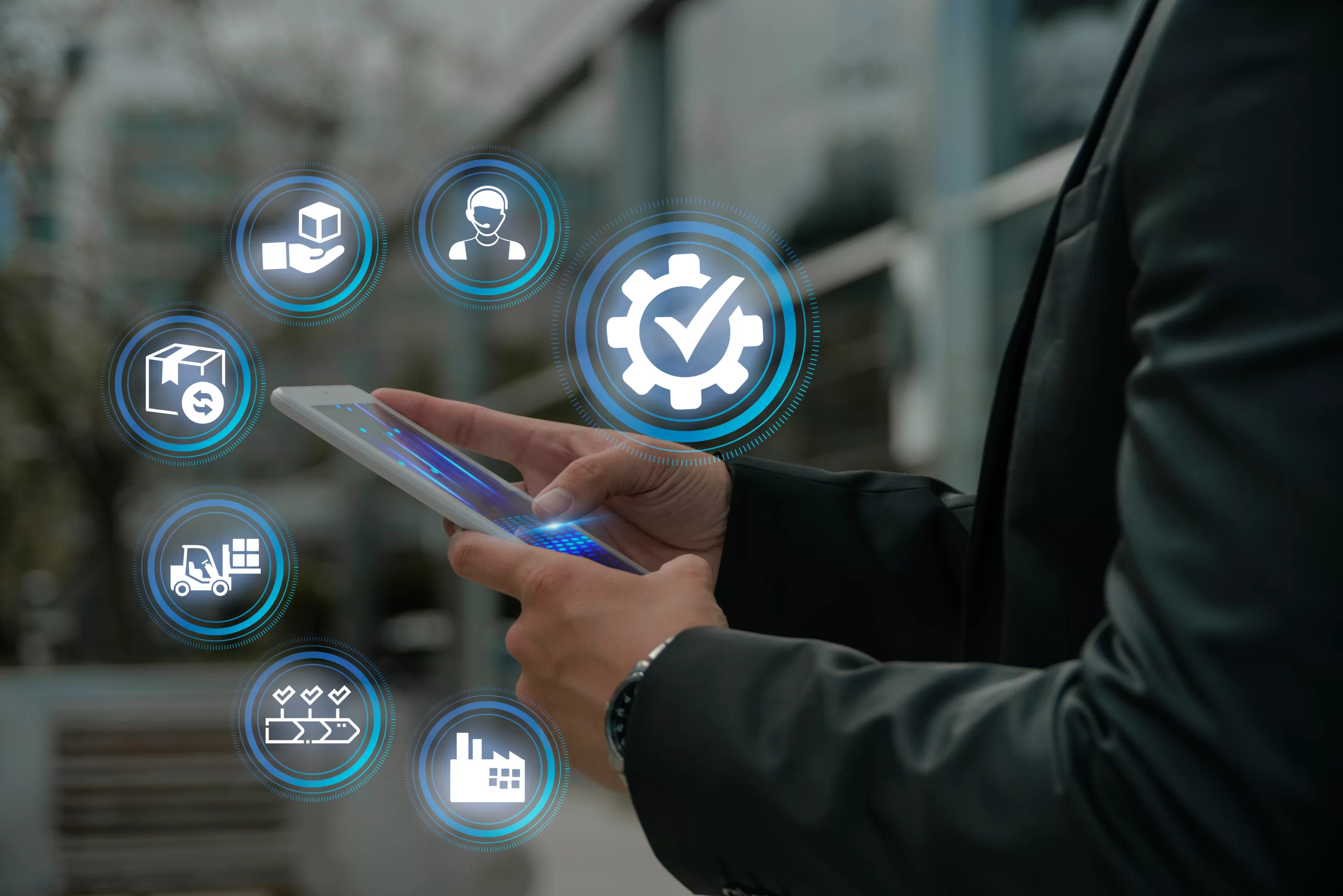 Professional using a tablet with blue holographic icons representing logistics and automation hovering around.